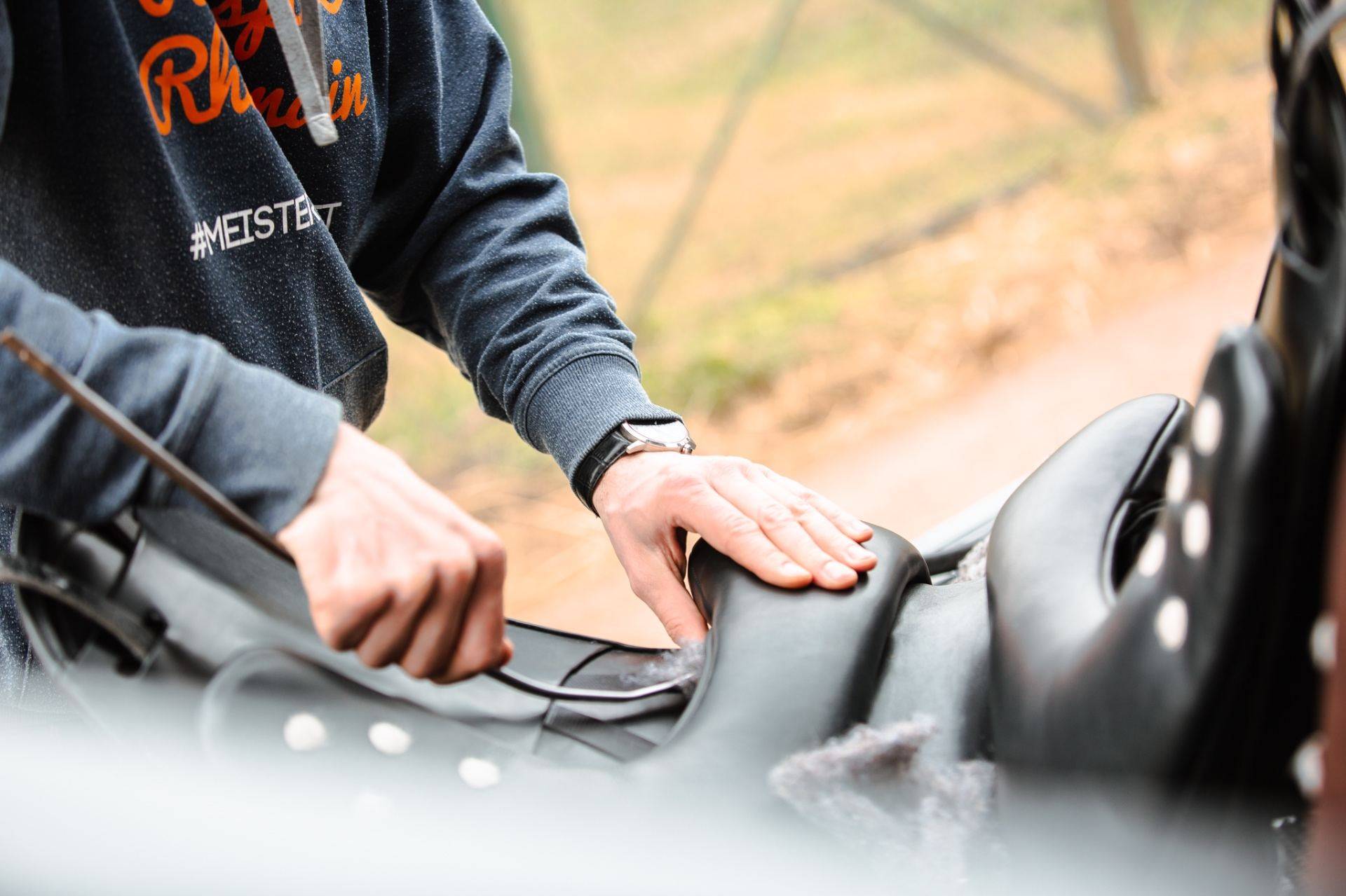Sattlermeister Magnus Wehrheim bei der professionellen Sattelanpassung am Pferd im Stall
